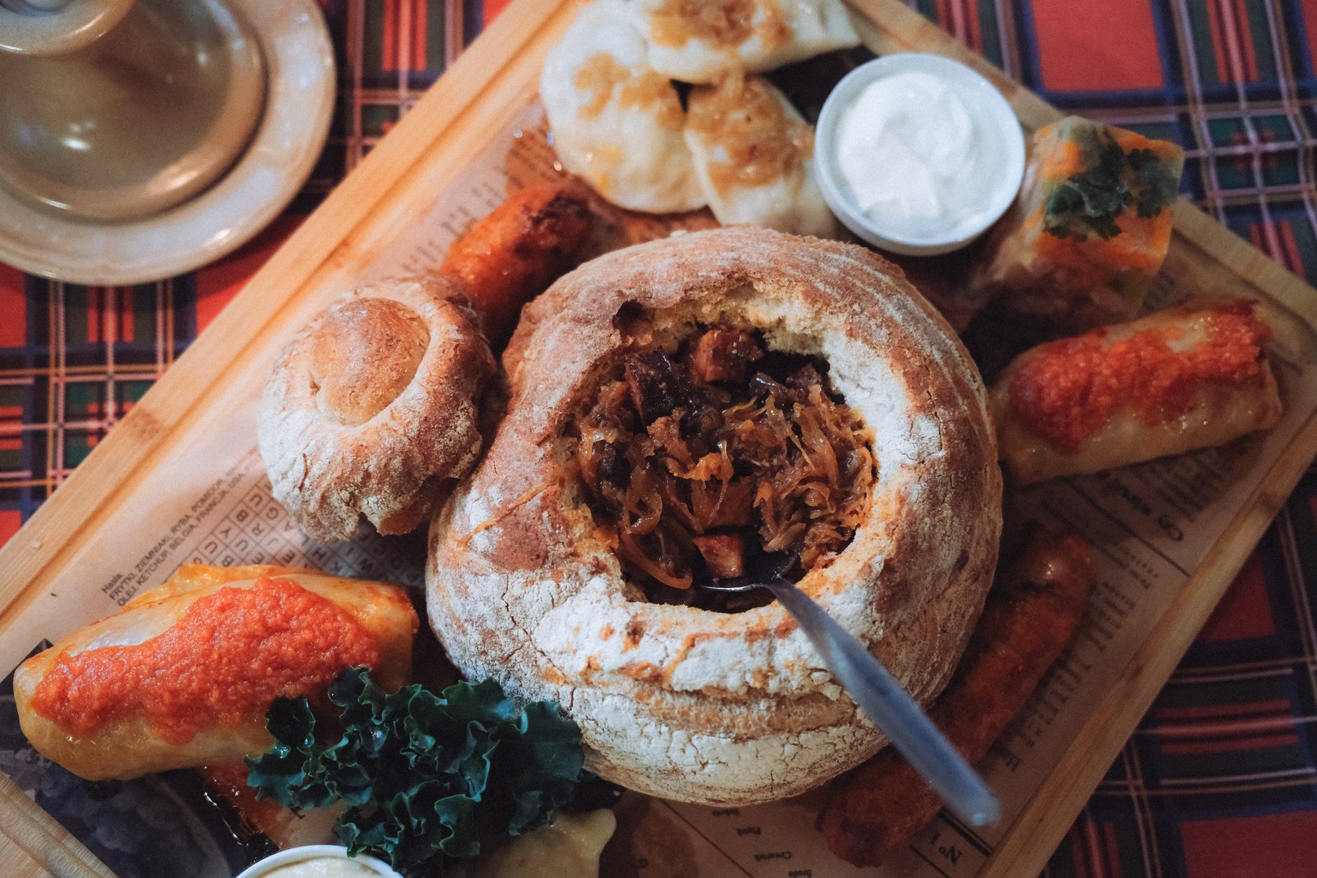 ciemny gulasz z knedlikami i krążkami cebuli na wierzchu
