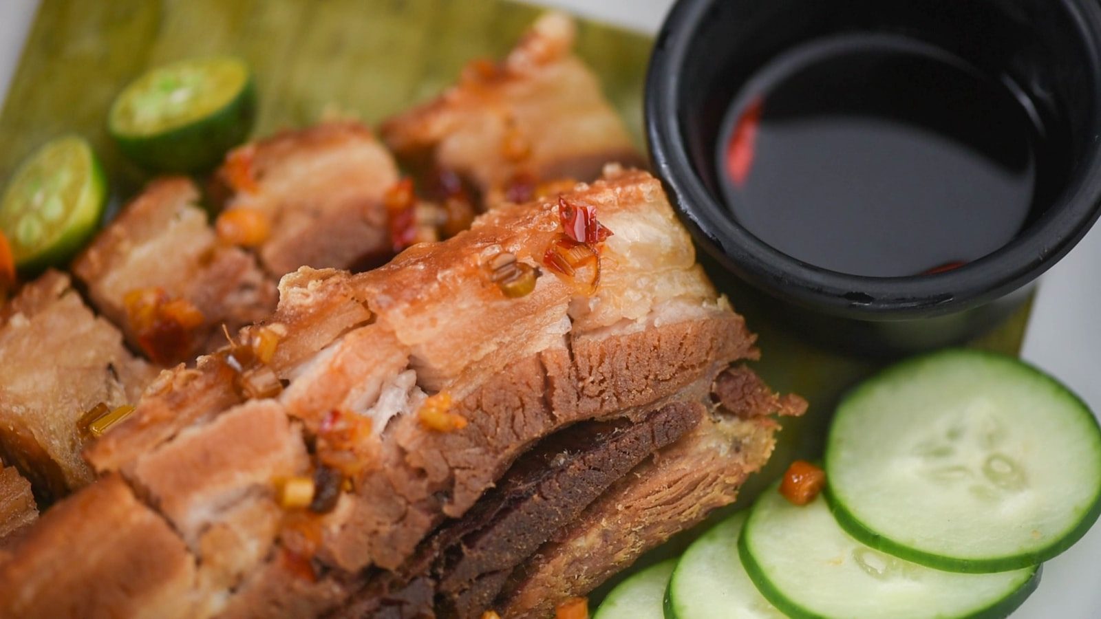 lechon o mahoniowej chrupiącej skórze na bambusowym rożnie nad węglami