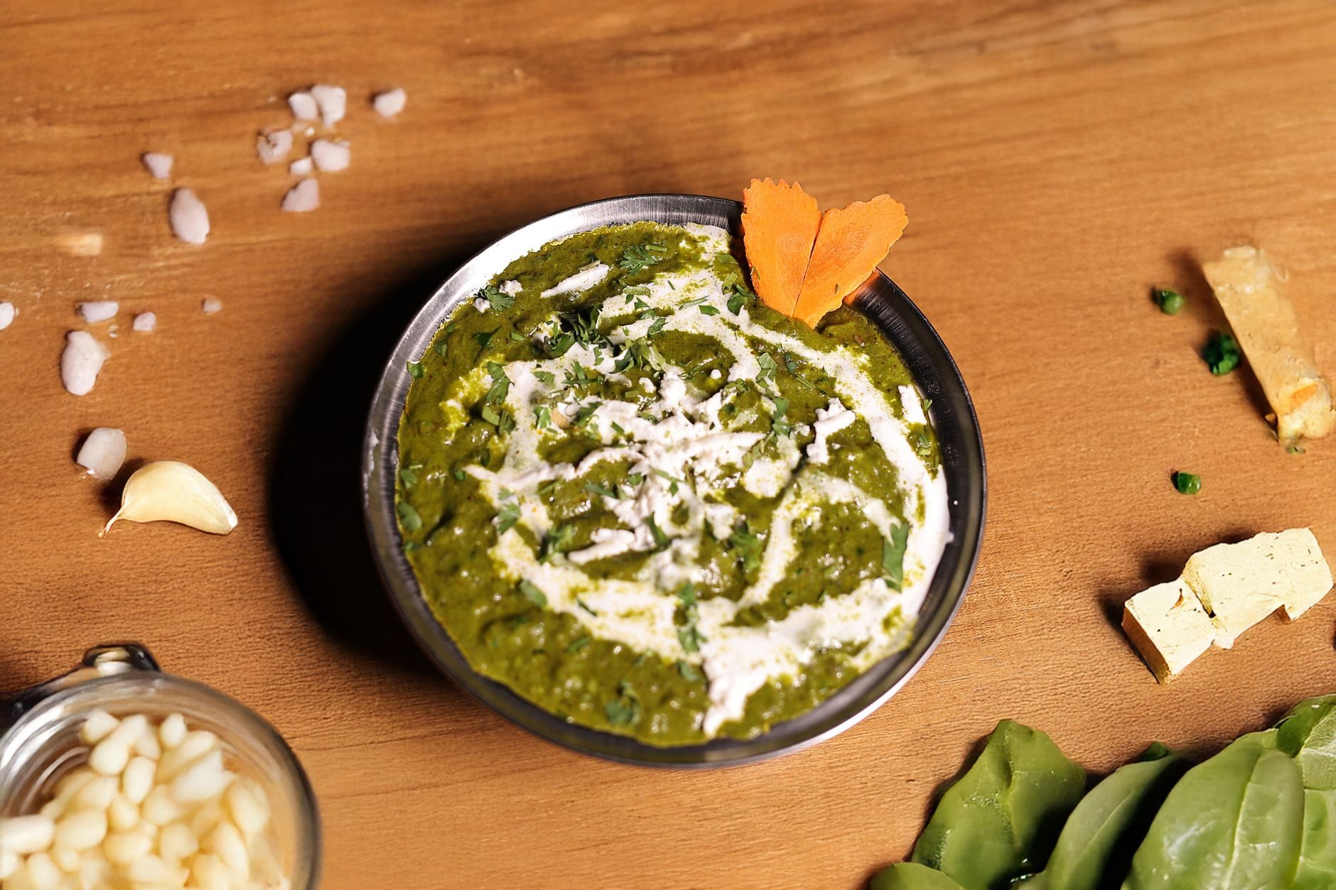 zielone palak paneer z kostkami sera i kleksem śmietany