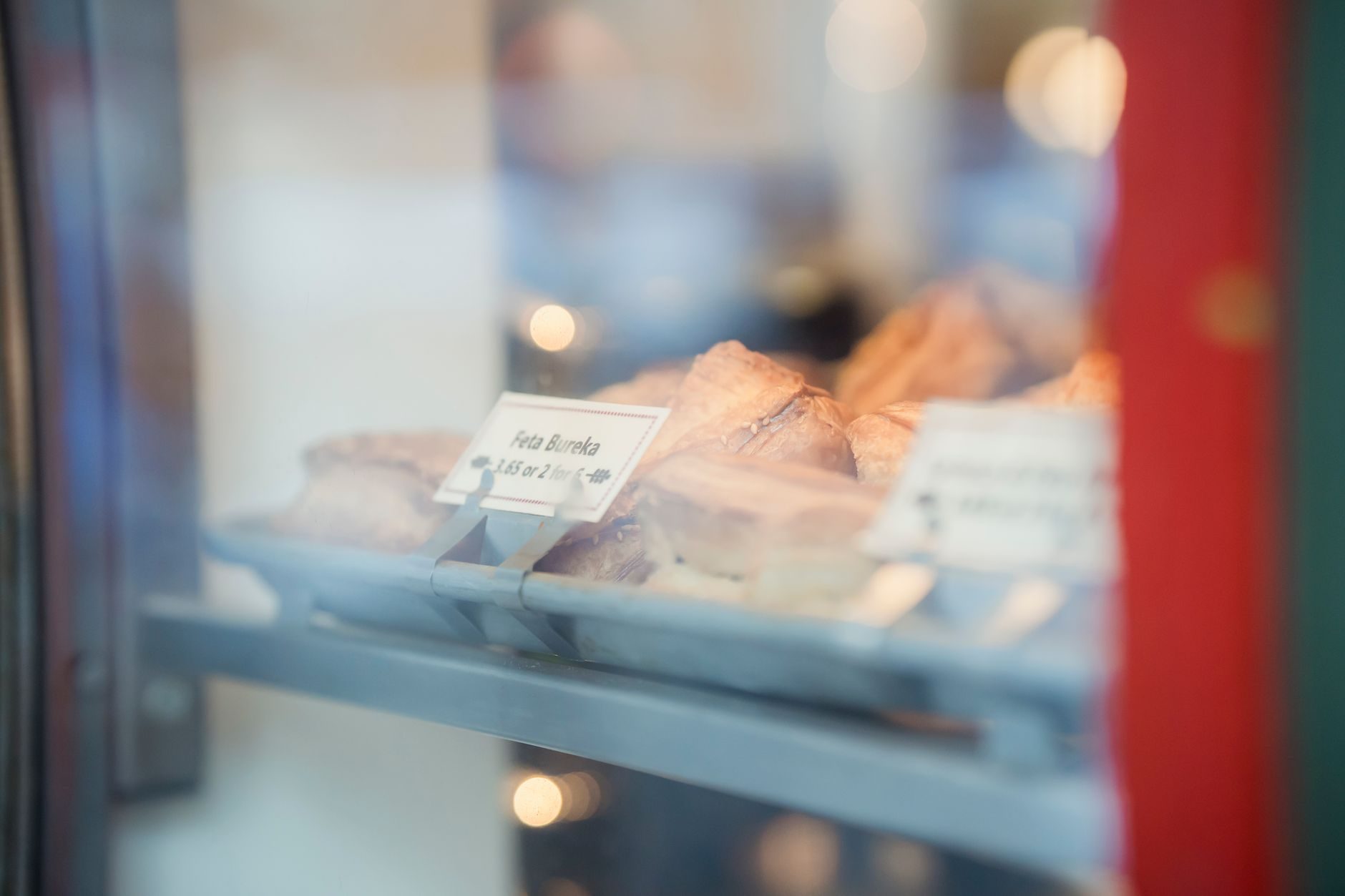 złociste trójkątne burekas posypane sezamem na blasze piekarni