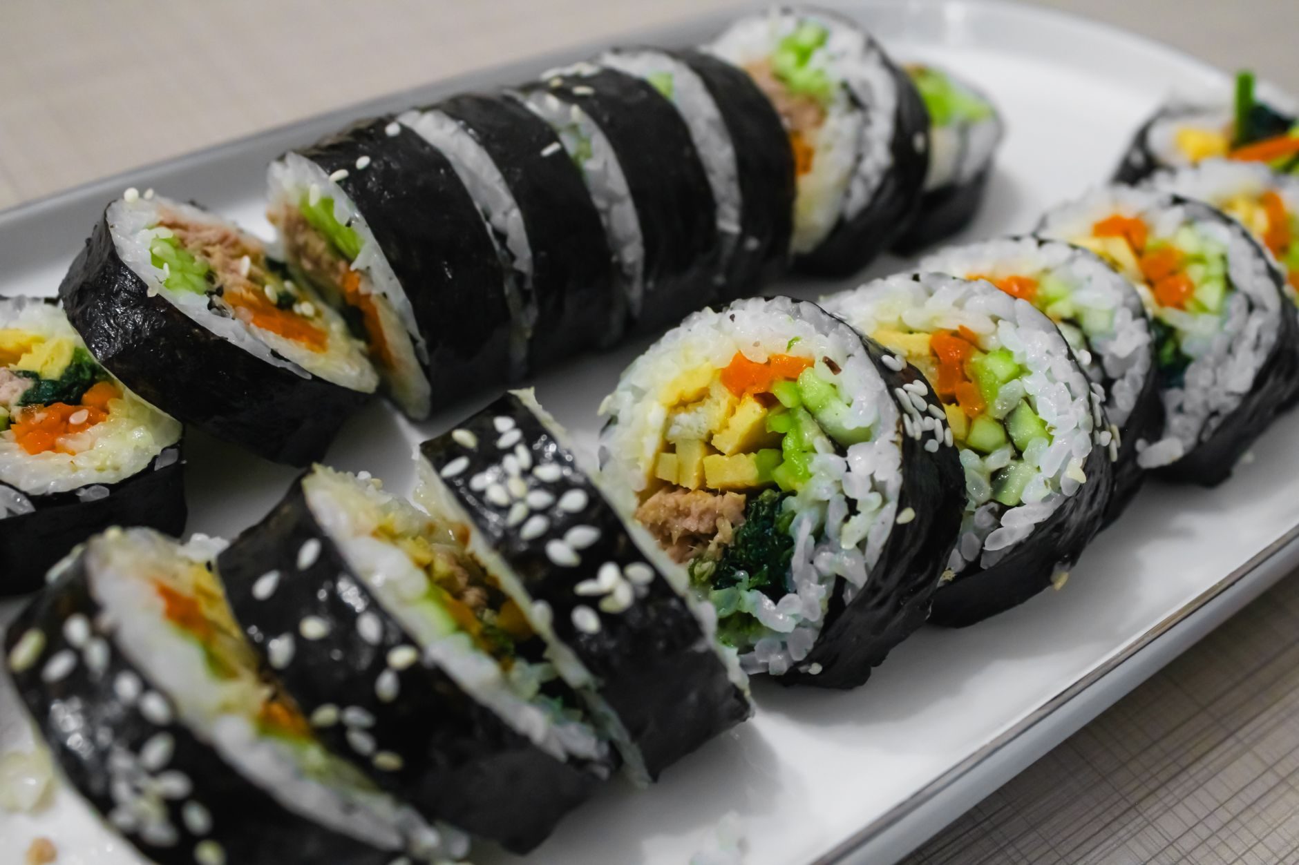 krążki gimbap z kolorowym środkiem ułożone na desce