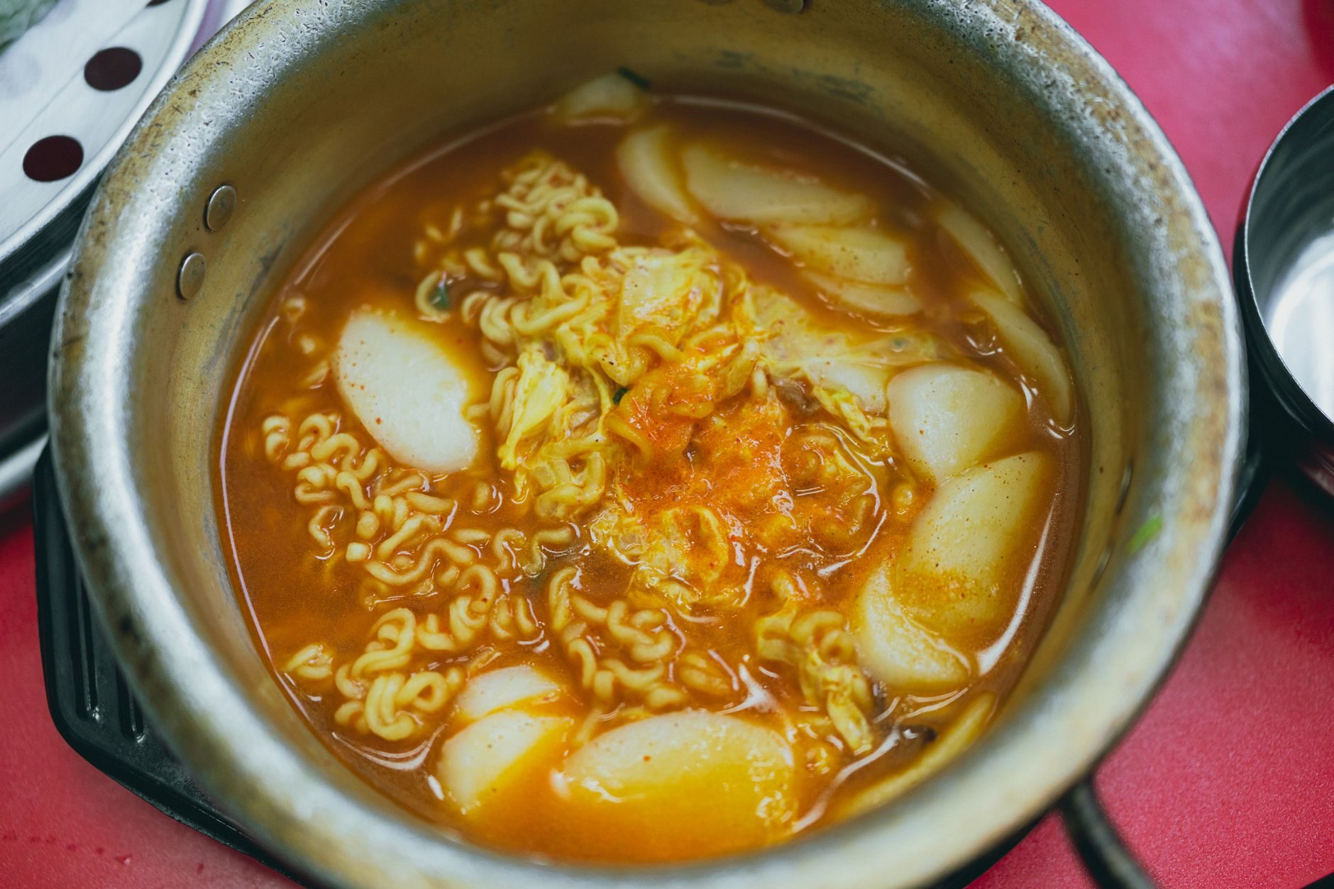 czerwone kluski tteokbokki z plackami rybnymi na straganie
