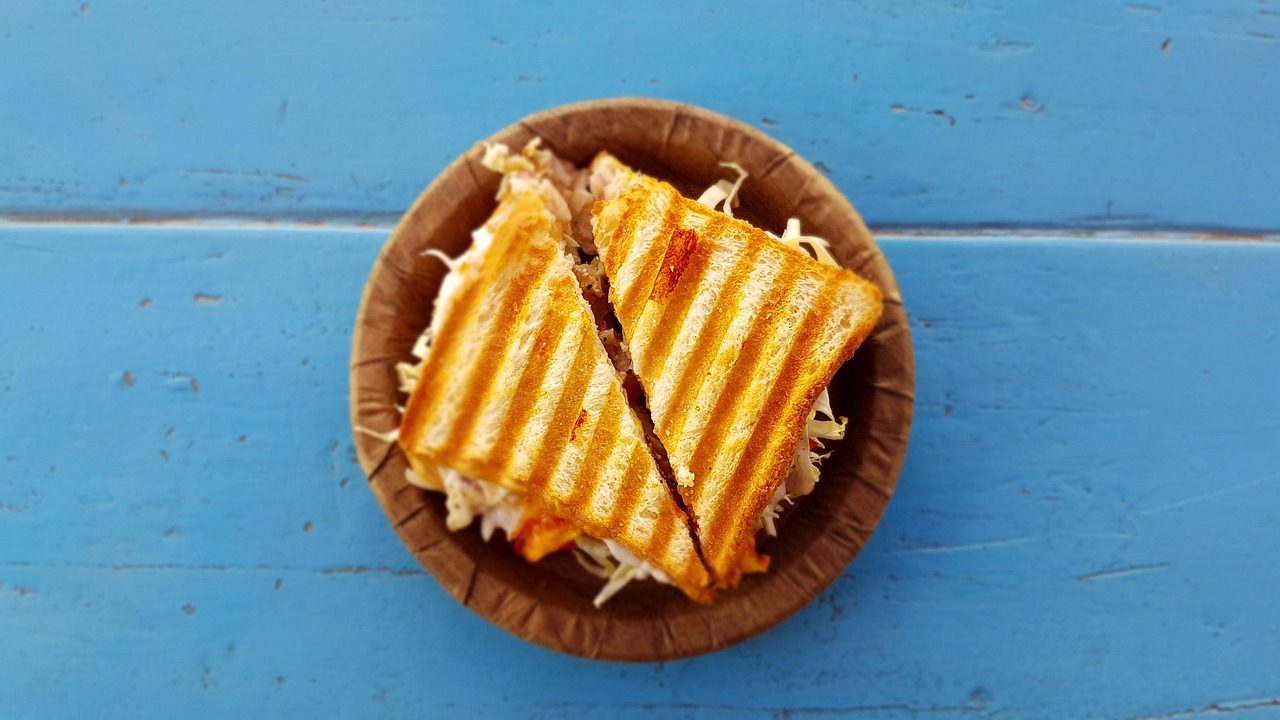 kaya toast z kostką masła obok jajek na miękko i szklanki kawy kopi