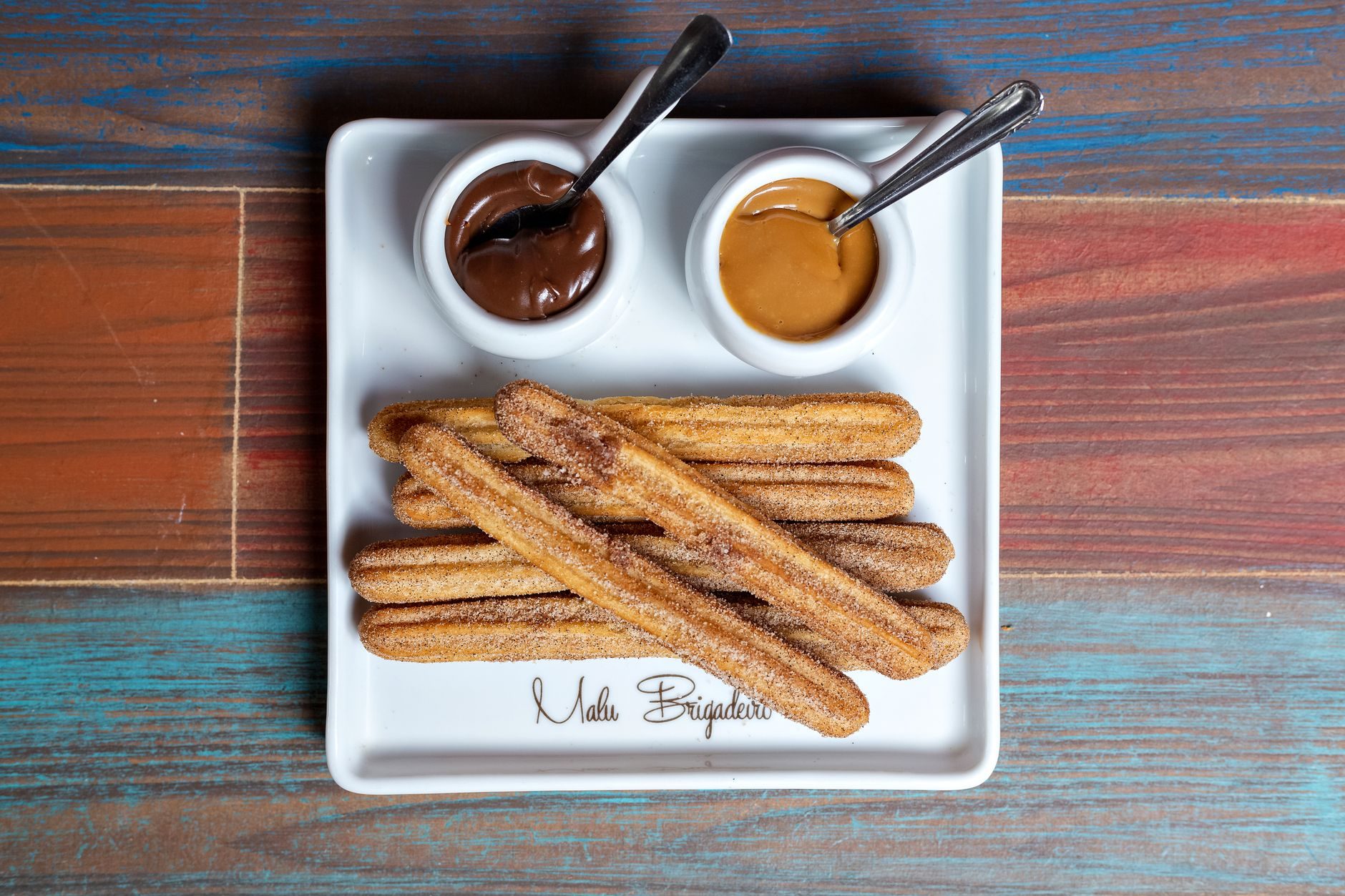Churros posypane cukrem cynamonowym z sosem czekoladowym