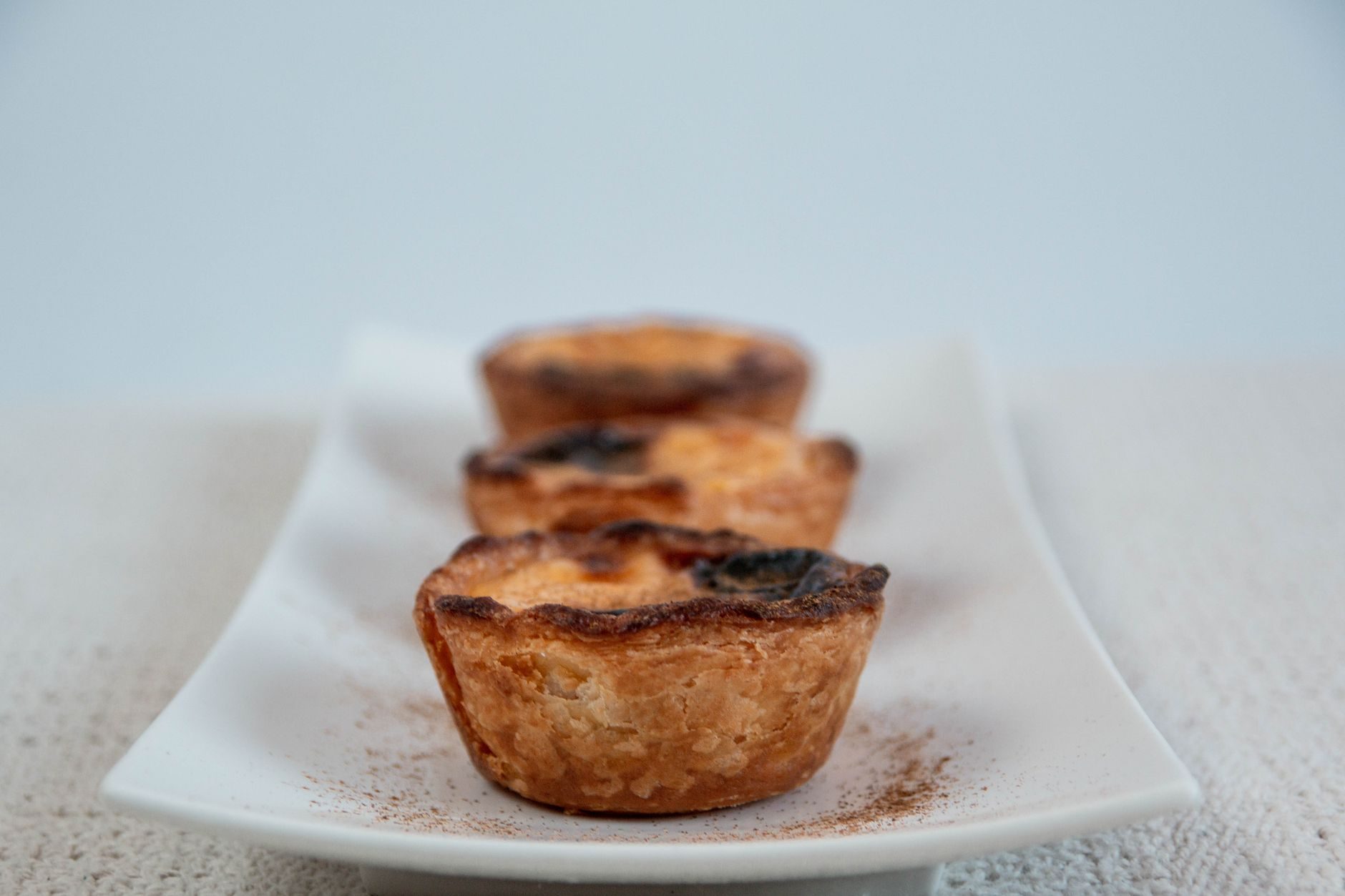 pastel de nata z przypalonym wierzchem posypany cynamonem