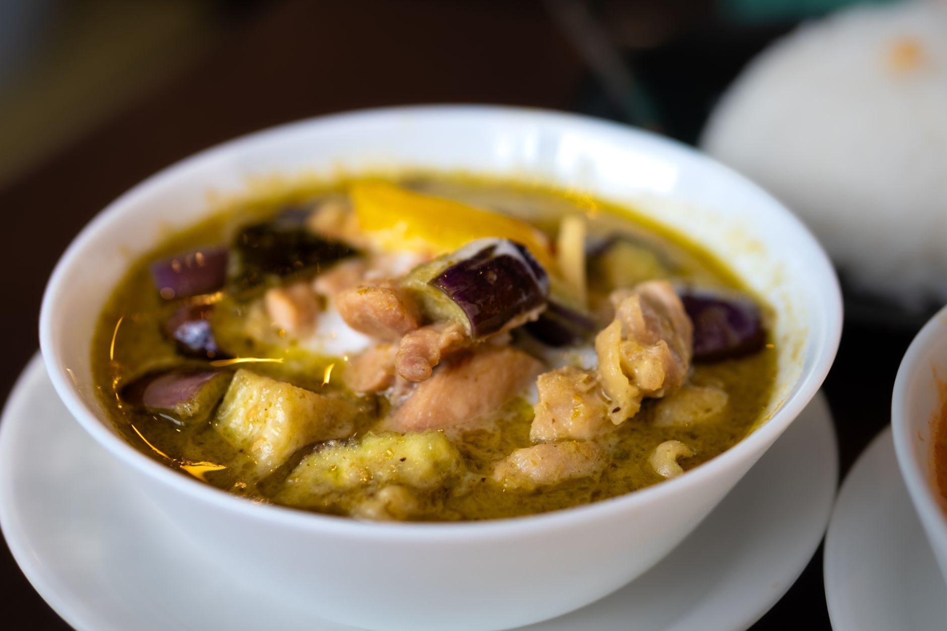 zielone curry z kurczakiem i bakłażanami w miseczce z ryżem obok