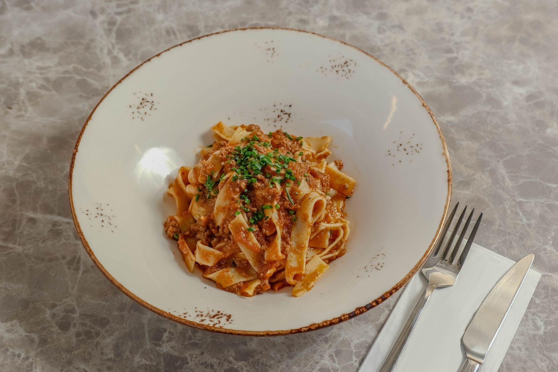gniazdo tagliatelle z gęstym mięsnym ragù i parmezanem